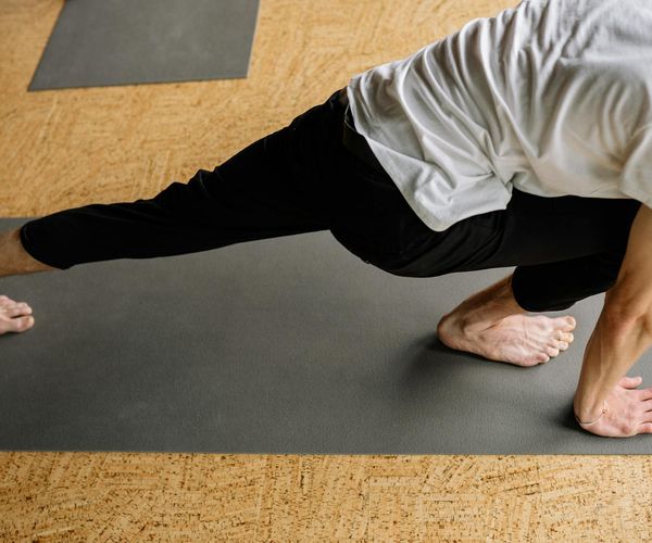 A focused man in a yoga posture, demonstrating balance and strength.